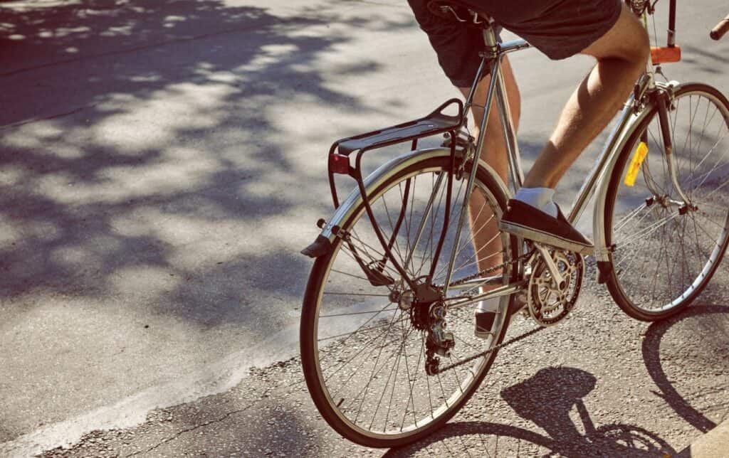 Close-up of the rear wheel of a silver hybrid bike.