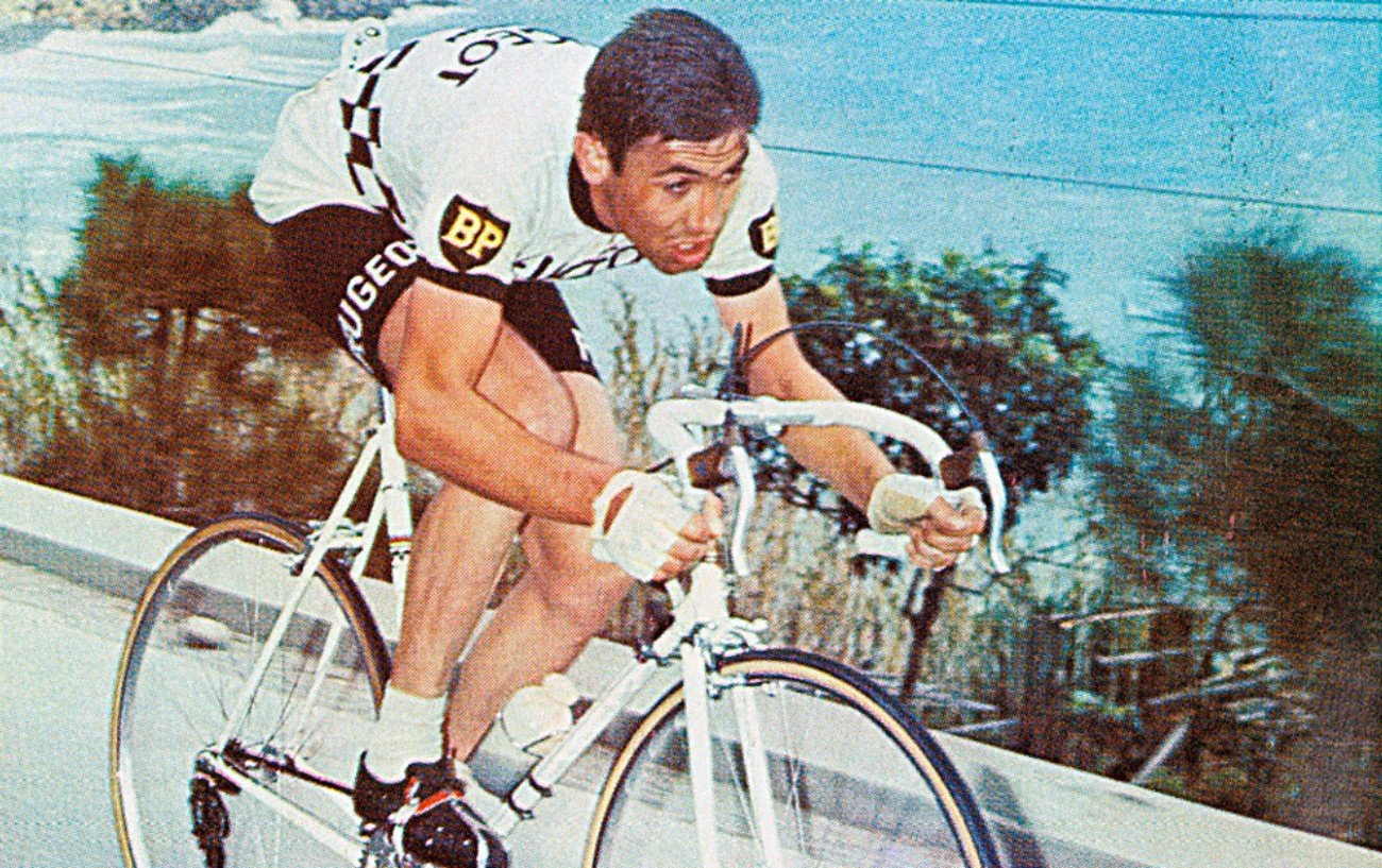 Eddy Merckx riding a white bicycle.