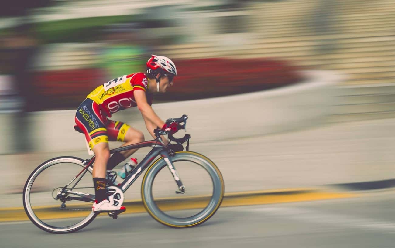 A cyclist on a black road bike competes in a race.
