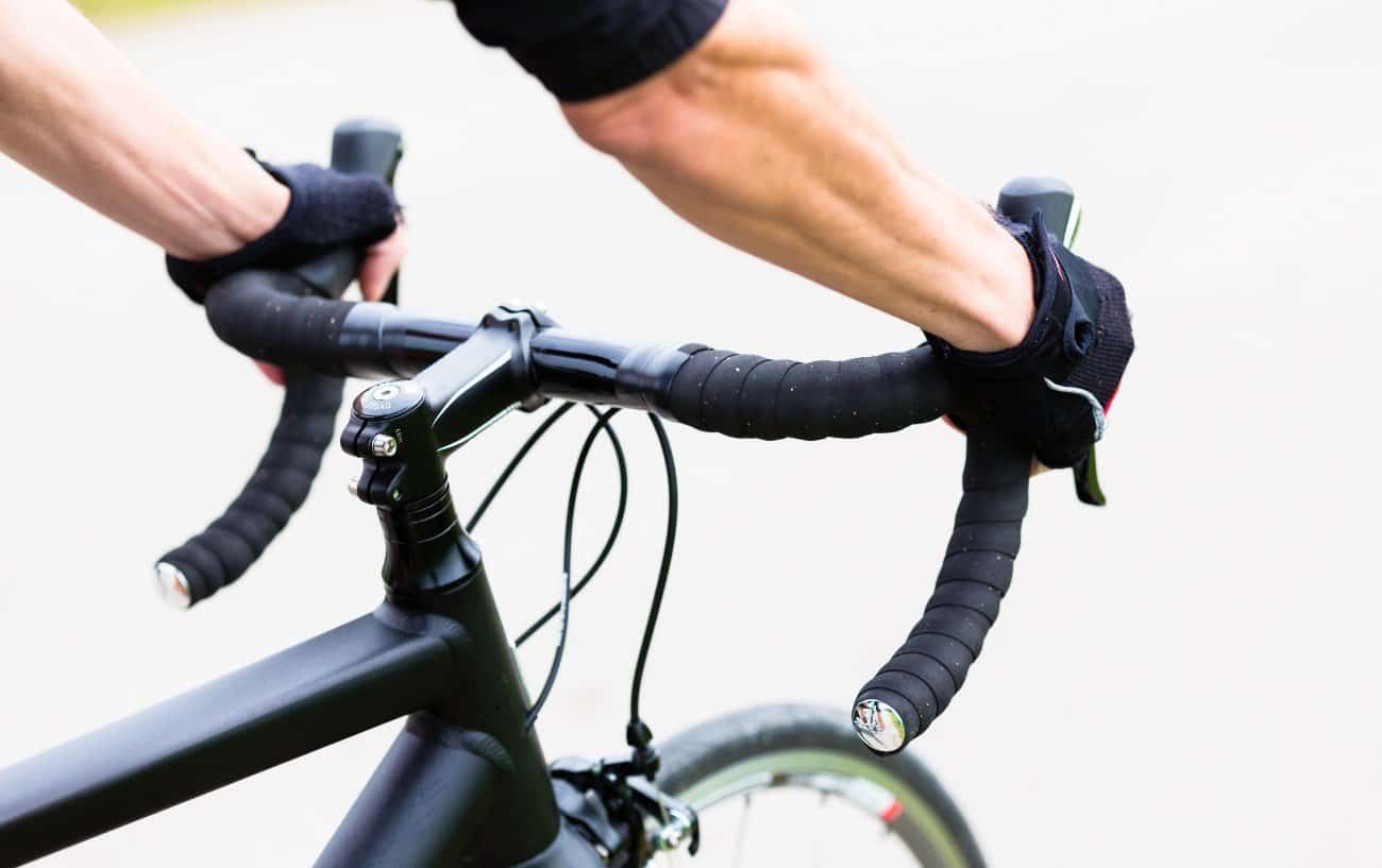 A set of black drop handlebars fixed to a road bike.