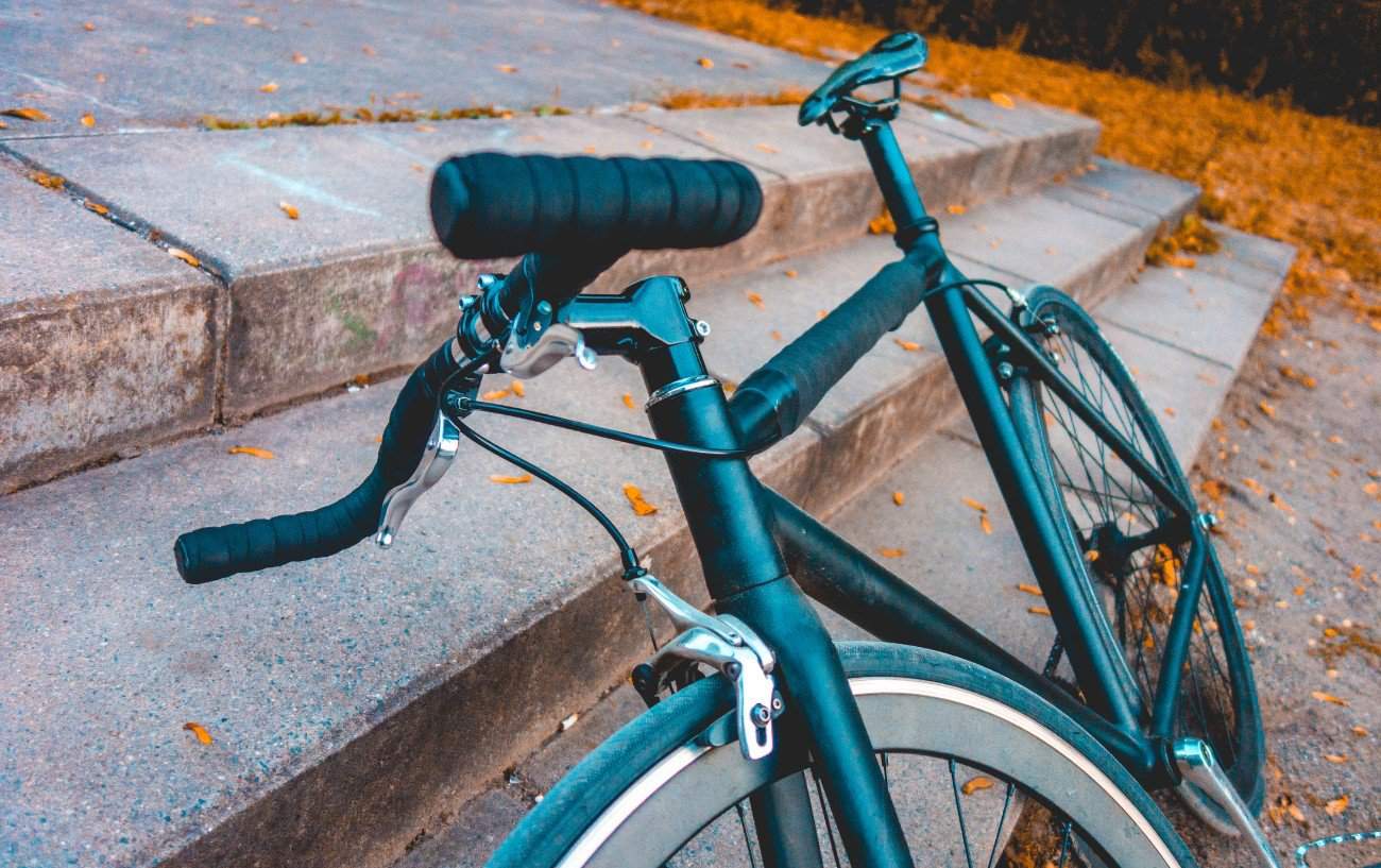 Bullhorn handlebars attached to a black fixed-wheel bike.