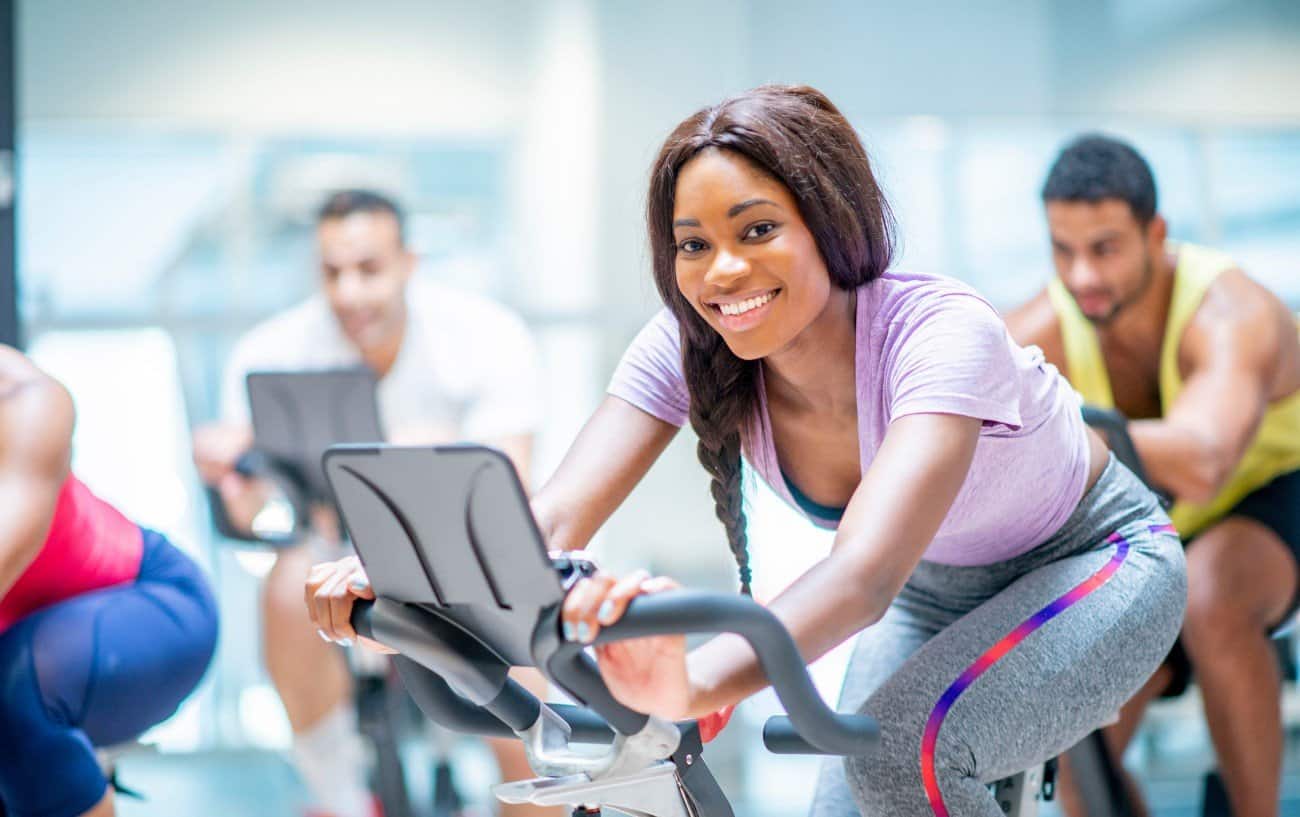 Woman riding a Peloton bike as part of a class.