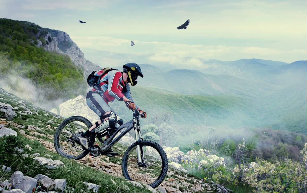 Mountain biker takes on a descent down a misty valley.
