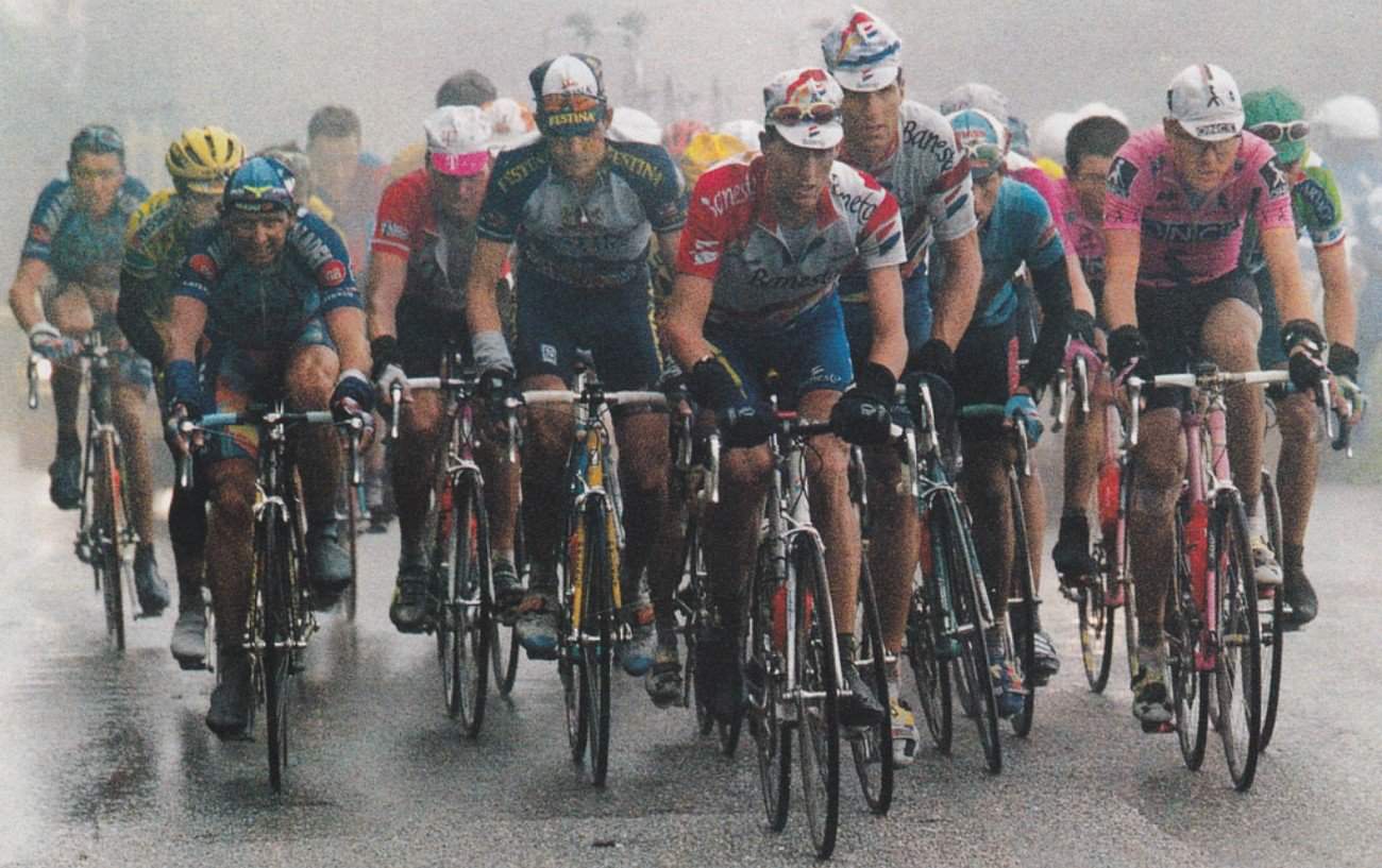 The peloton climb a hill in the rain at the 1996 Tour de France.