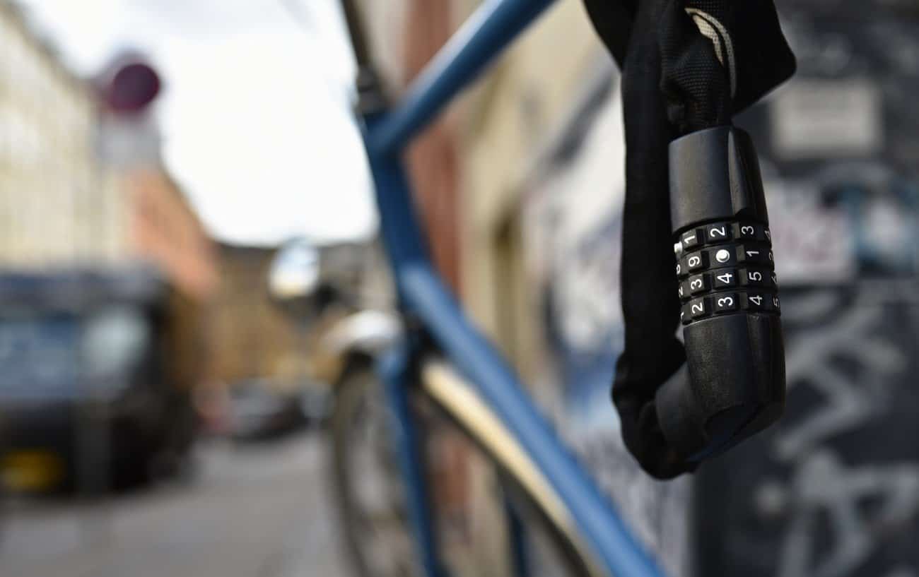 Combination lock wrapped around a blue city bike.
