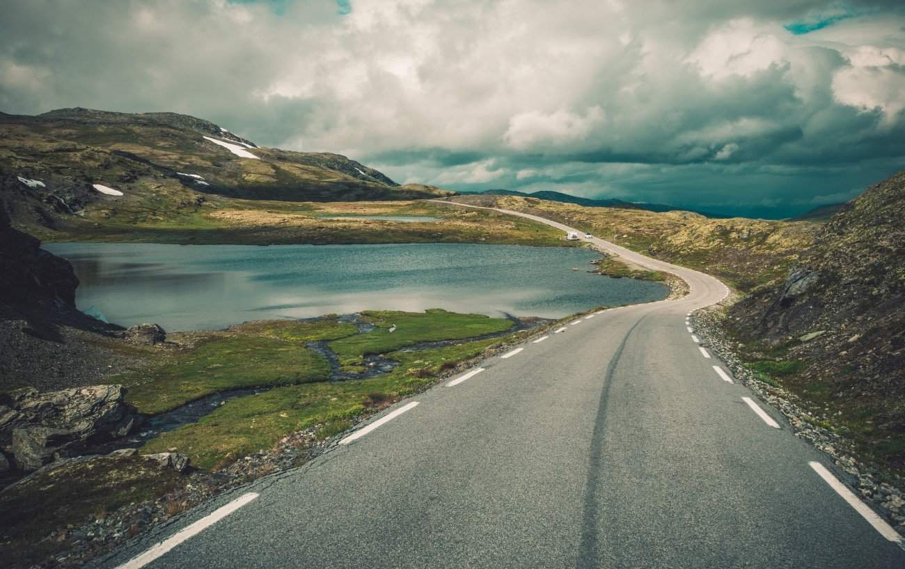 A tarmac road snakes across the rugged Scottish landscape.