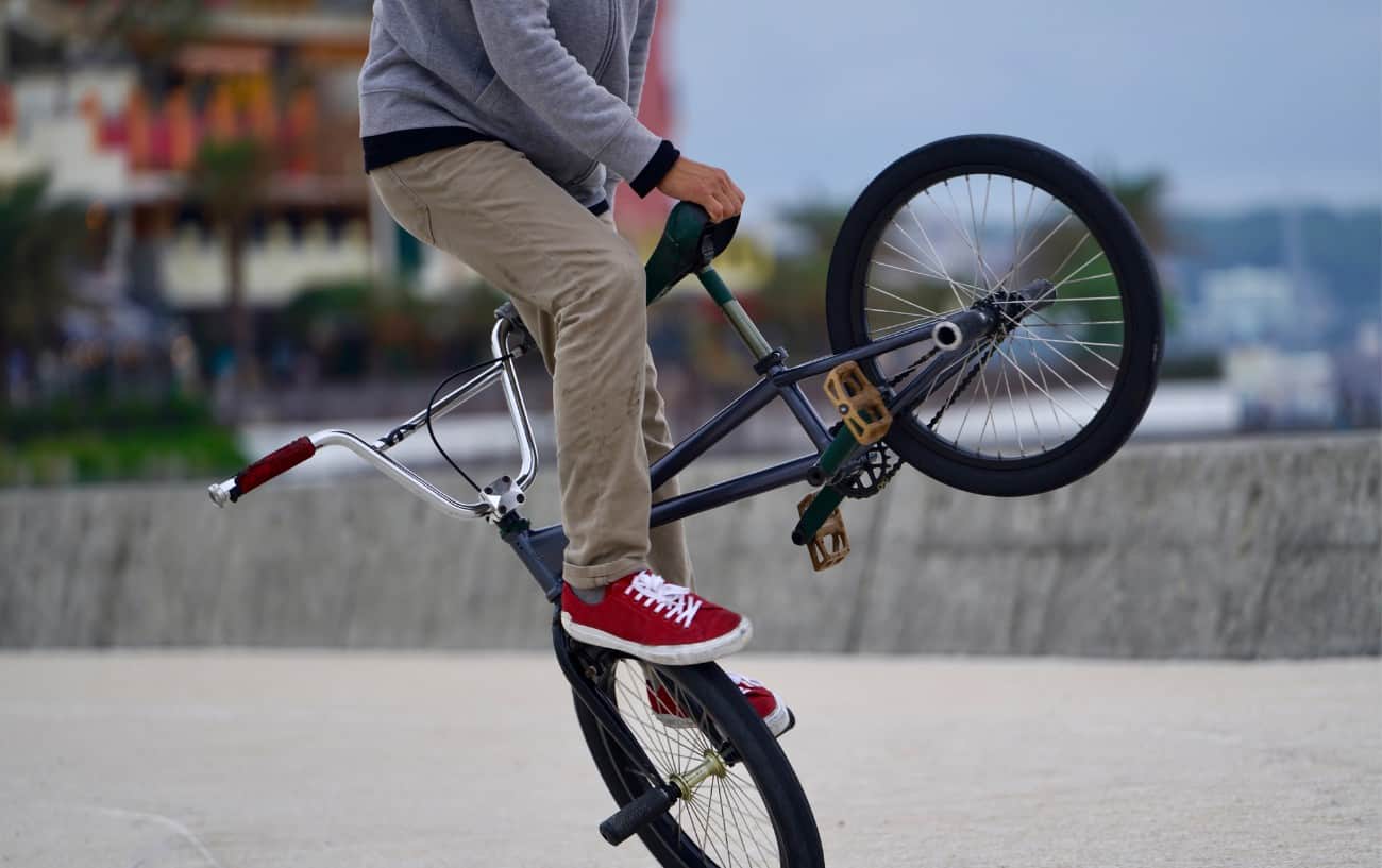 A BMXer performs acrobatics on flat ground.