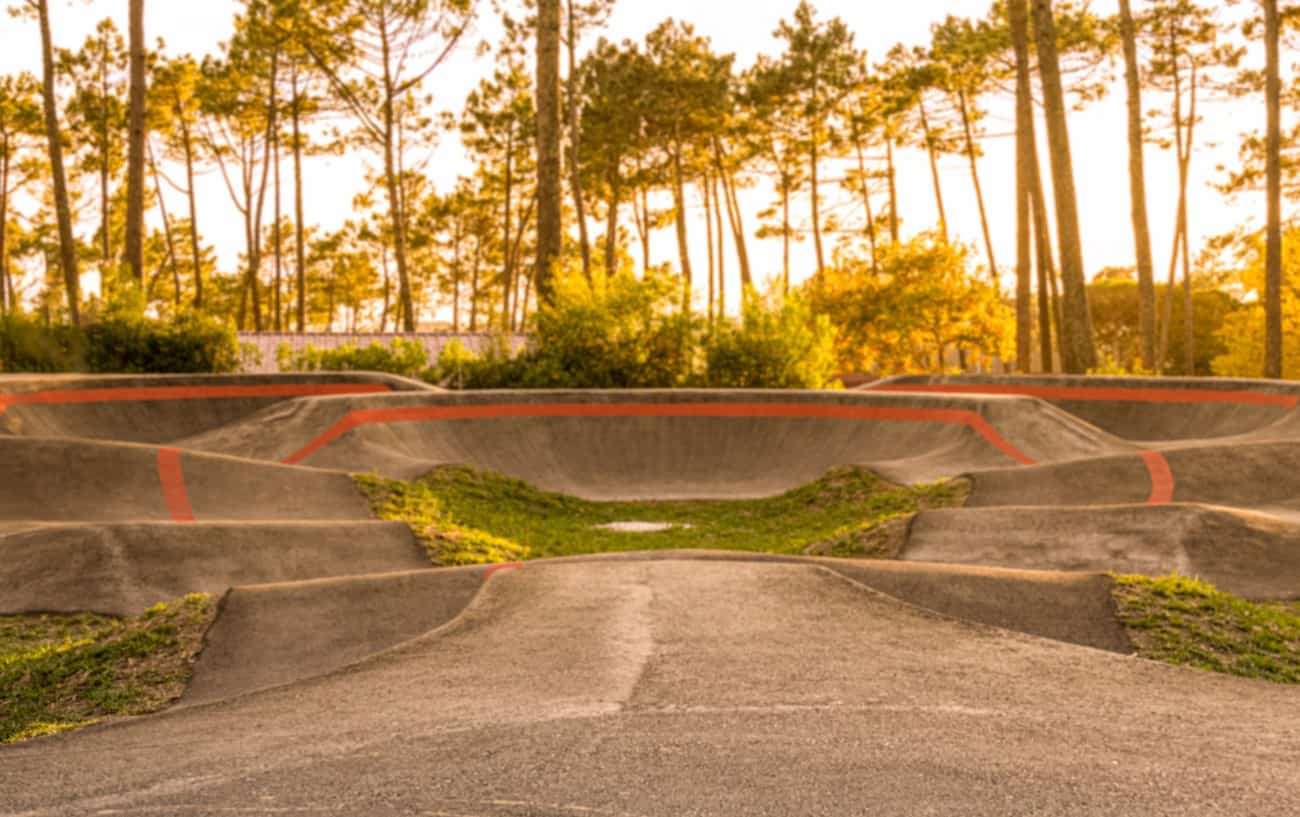 A pump track in a forest at sunset.
