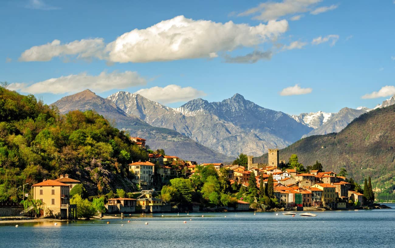 Scenic photo of a village on Lake Como with the Italian Alps in the background.