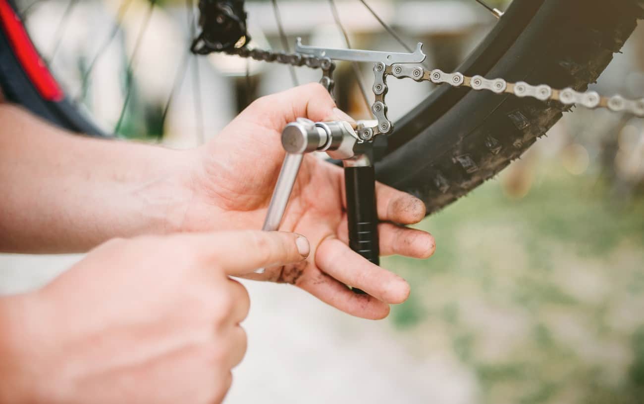 Using a chain tool to reconnect a broken bike chain.