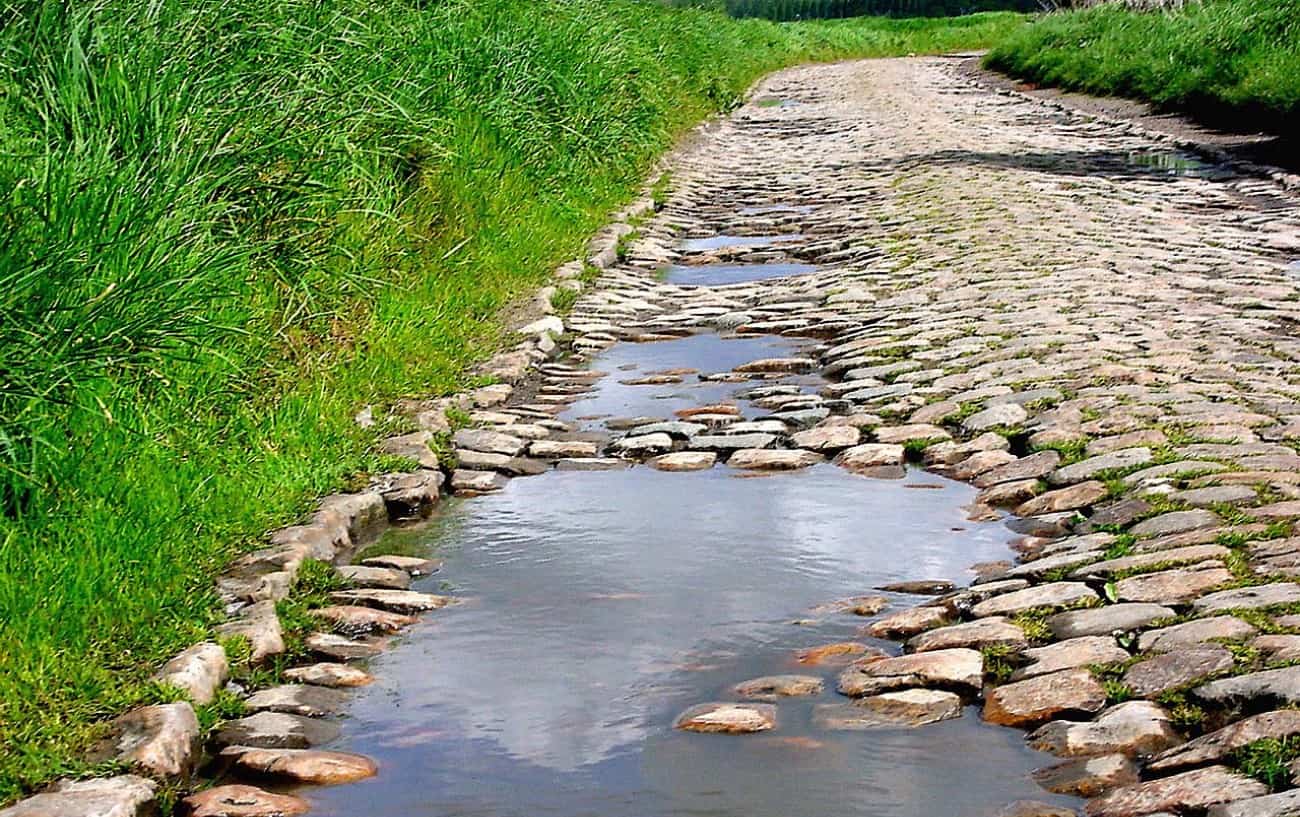A rough, flooded section of cobblestone road in northern France.