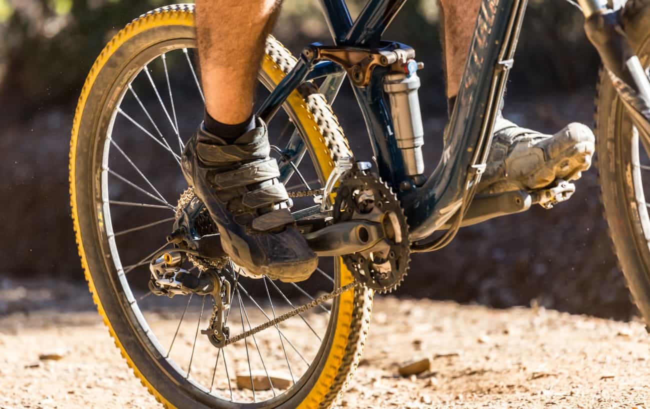 Close-up of the rear suspension on a black full-suspension mountain bike.