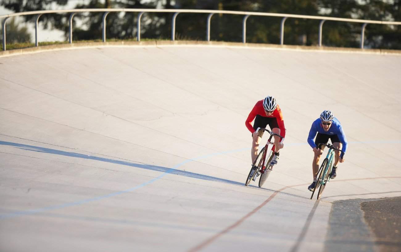 Two cyclists sprint for the line, riding out of the saddle.