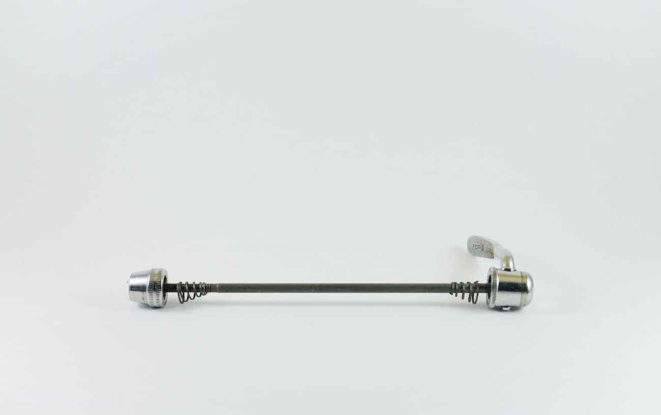 Quick release skewer against a grey background.