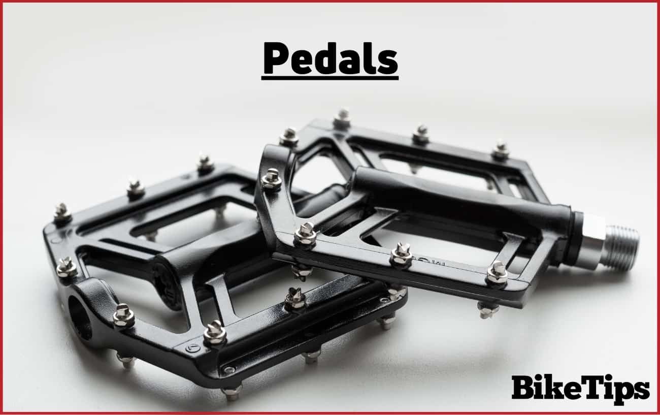 Photo of black flat pedals against a light grey background.