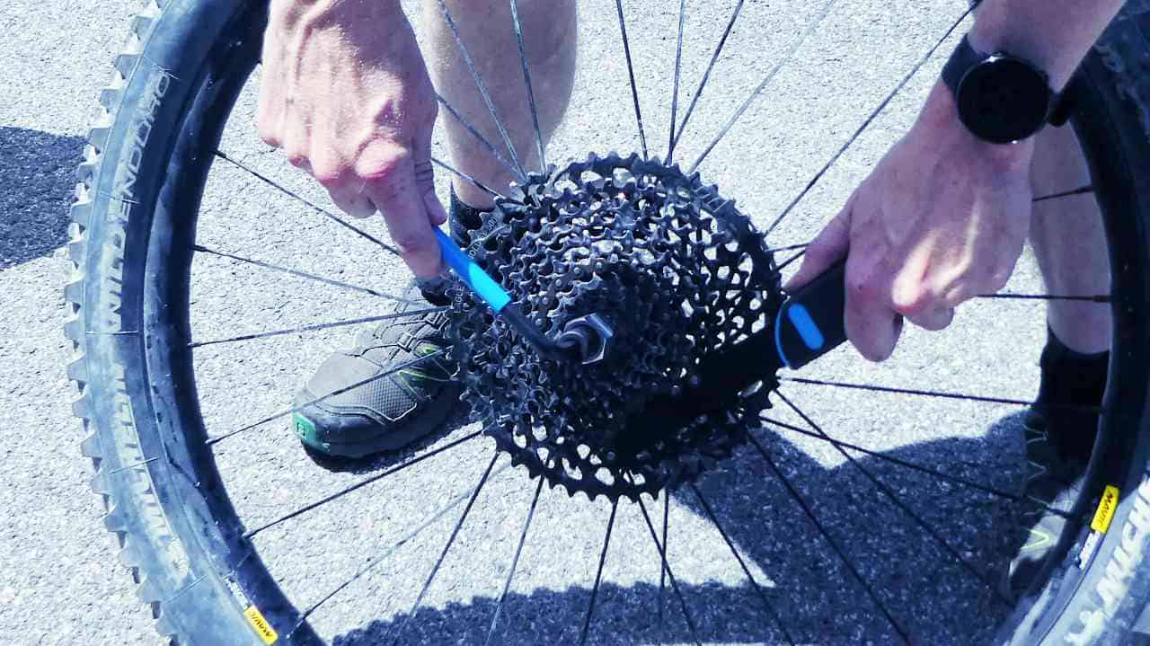 Unscrewing the cassette lockring with cassette tool and chain whip.