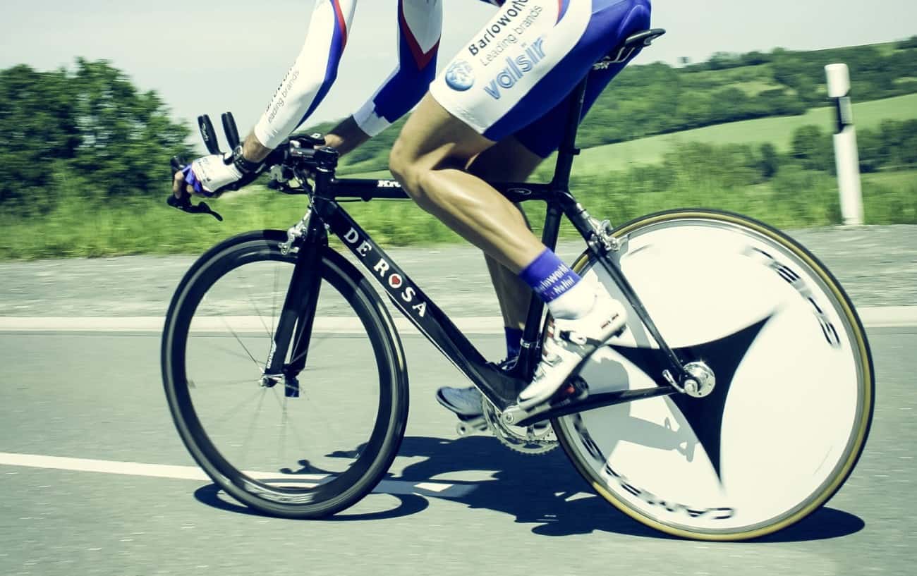 Close-up of a white disc wheel being ridden on a black road bike.