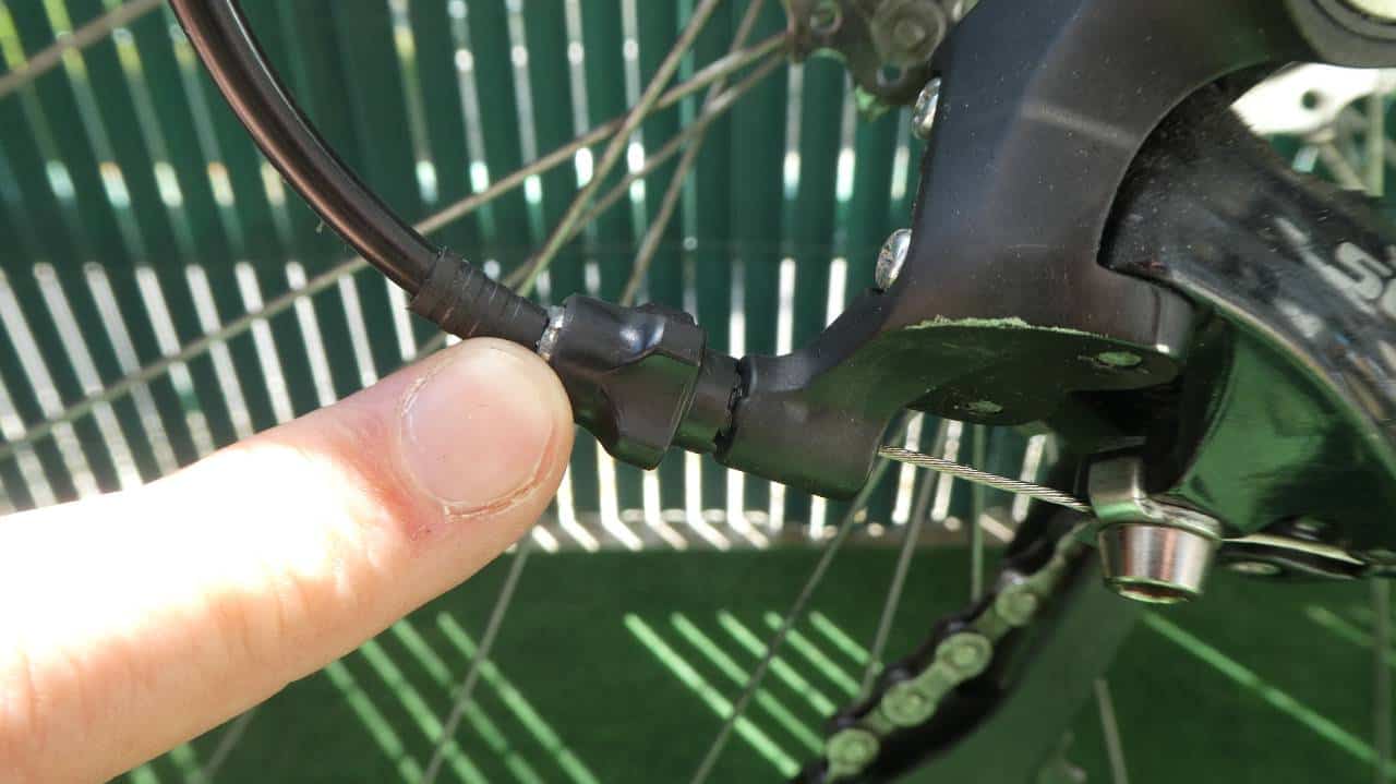Pointing out the barrel adjuster on the rear derailleur of a bike.