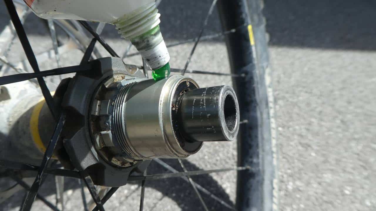 Applying grease to a bike's freehub.
