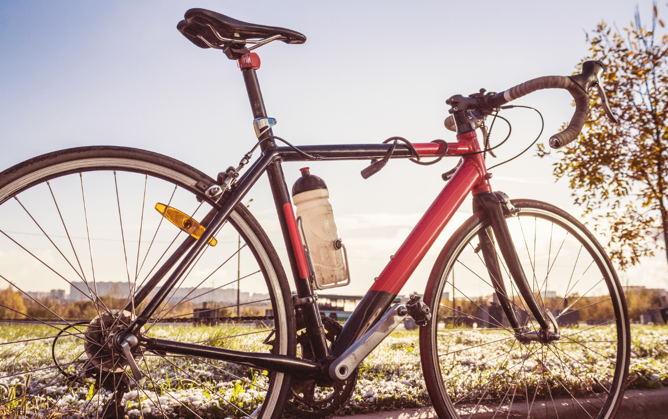 Touring bike vs road bike: photo of a black and red road bike in a frosty field.