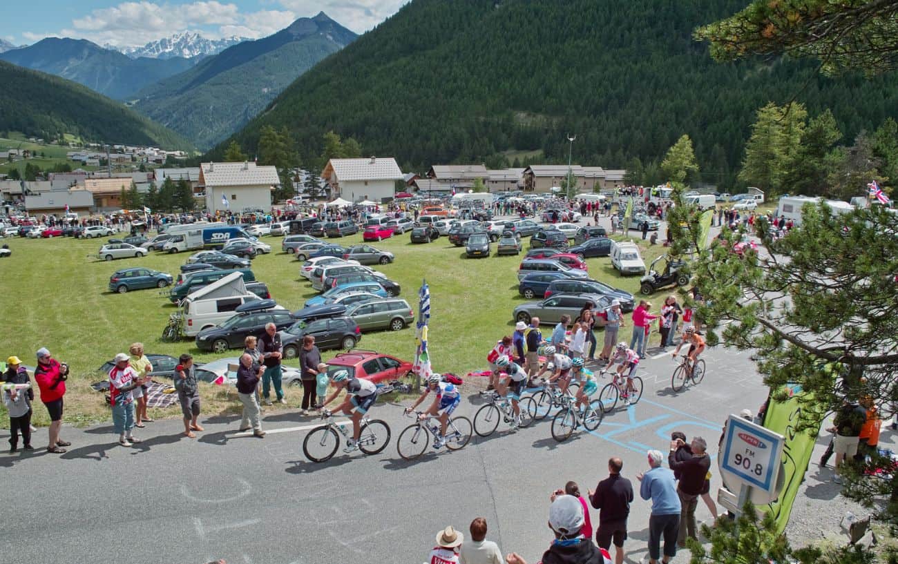 The peloton climbs a steep hill in a cycling race.