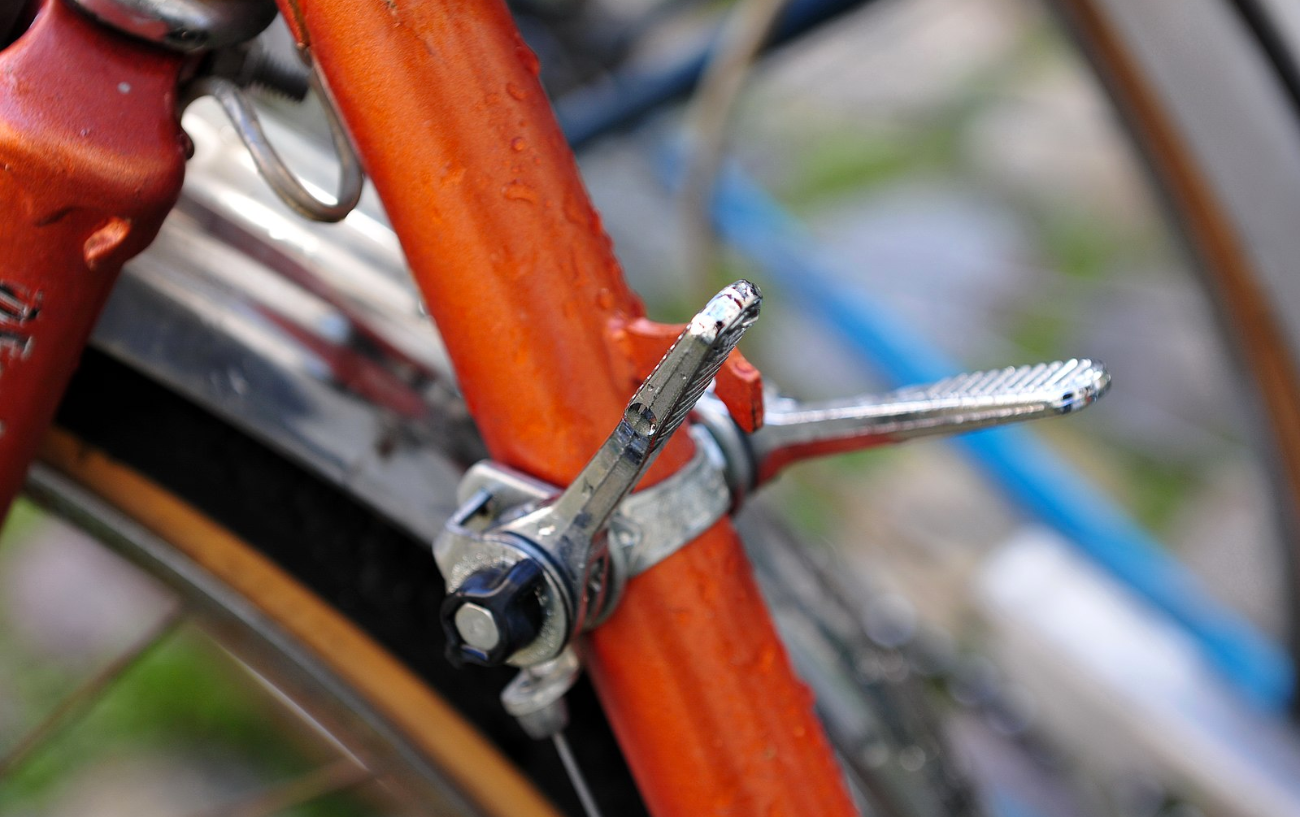 Down tube shifters (friction shifters) on an orange vintage bike.