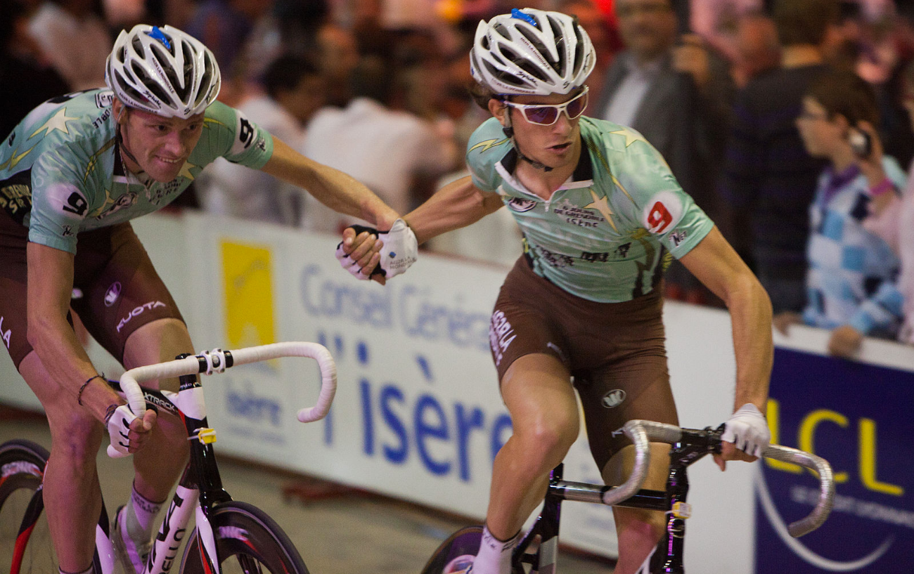 A hand-sling between teammates during the Madison at the Six Jours de Grenoble, 2011.