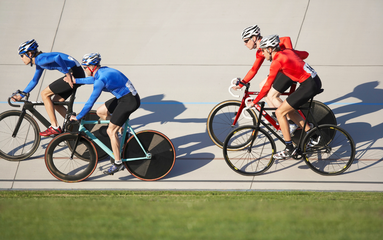 A blue team and a red team compete in a Madison cycling race.