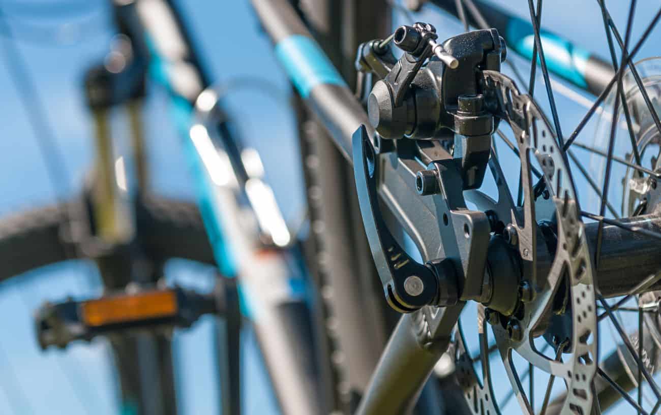 Close-up of disc brakes on a blue mountain bike.