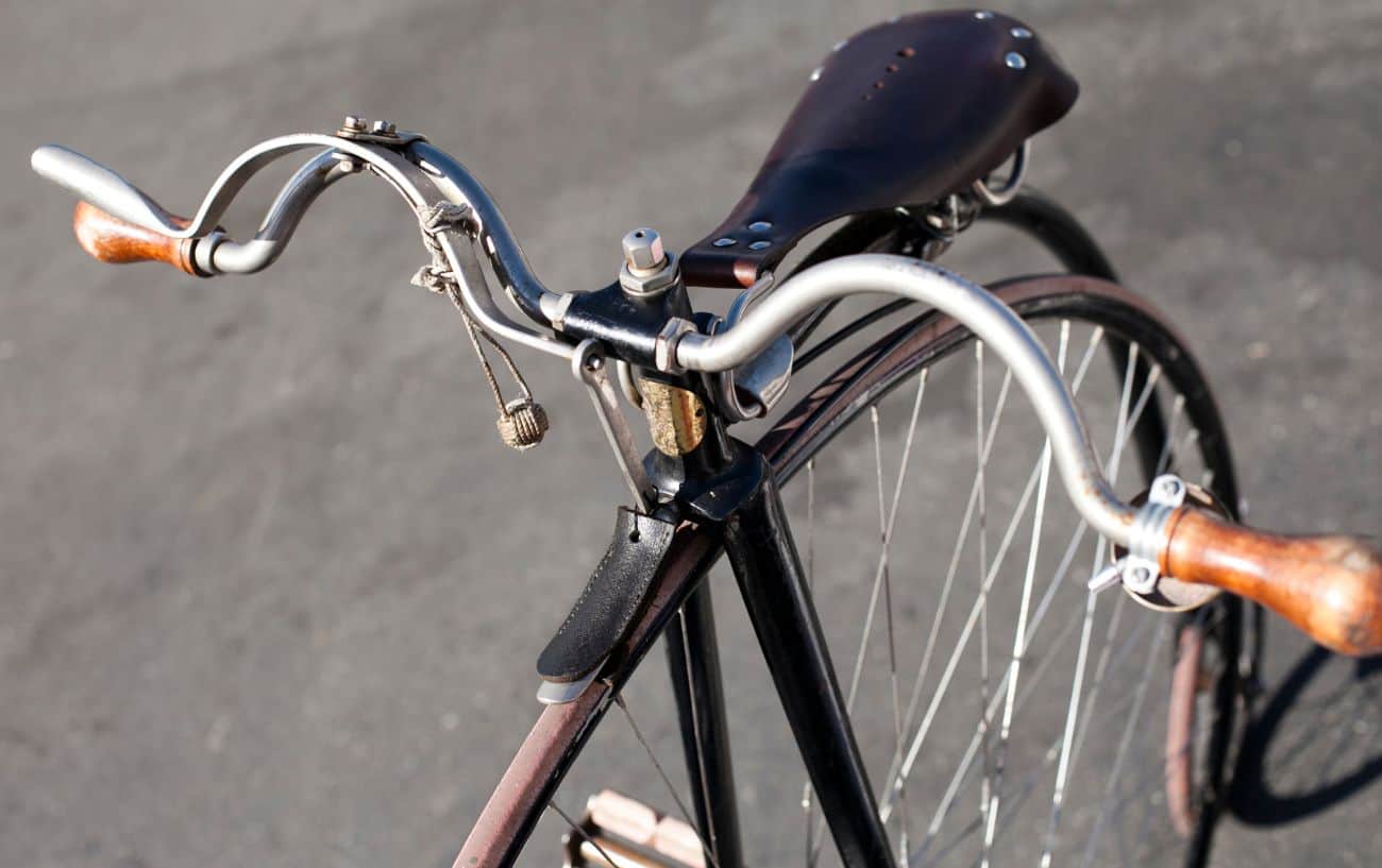 Close-up of the handlebars and saddle of a penny farthing bicycle.