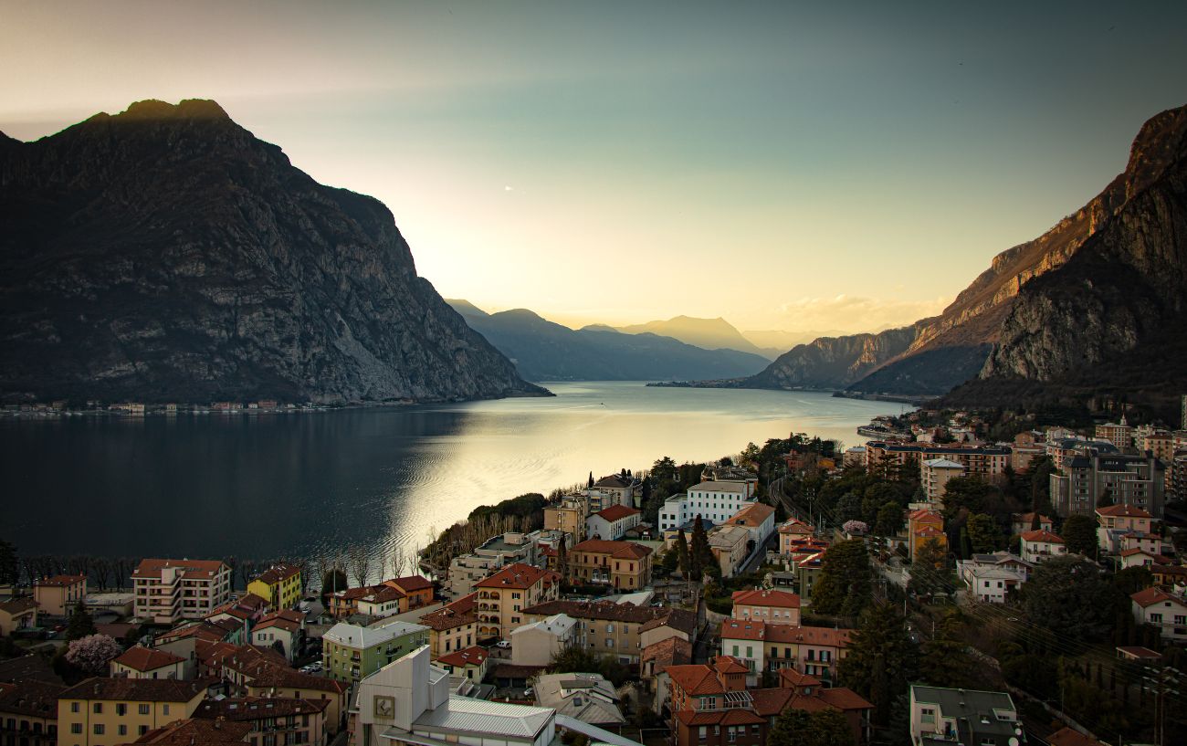 Autumnal view of a village on the banks of Lake Como at sunrise.