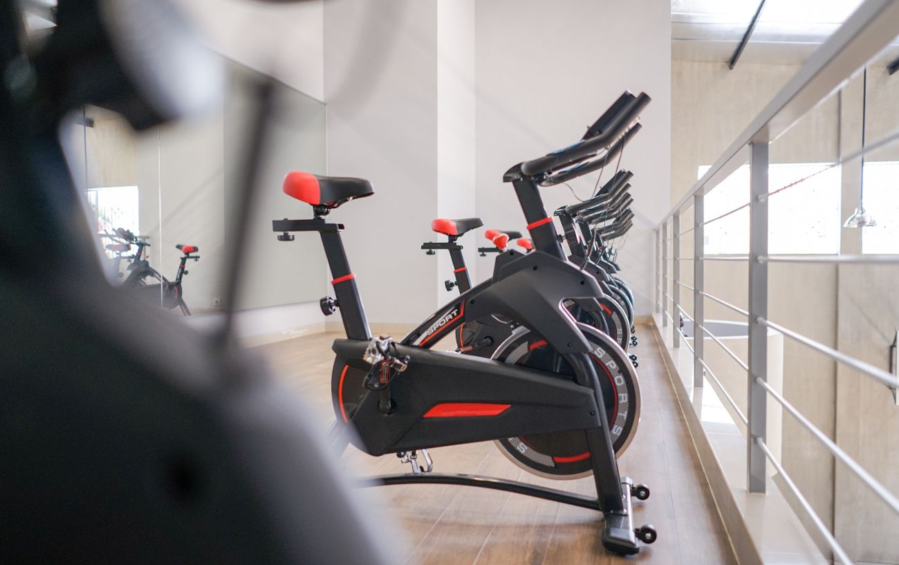 A row of black spin bikes at a gym.