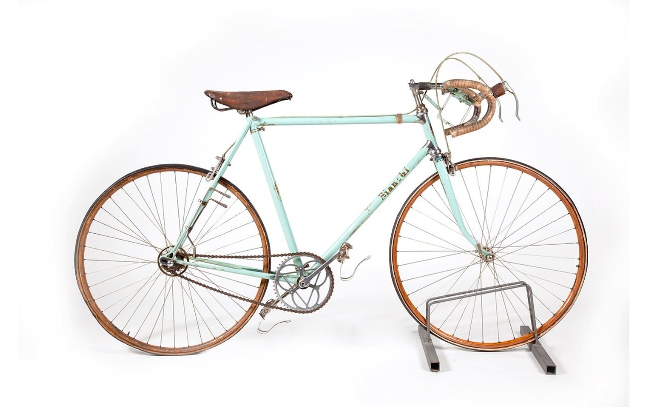 A vintage celeste Bianchi road bike stands against a white background.