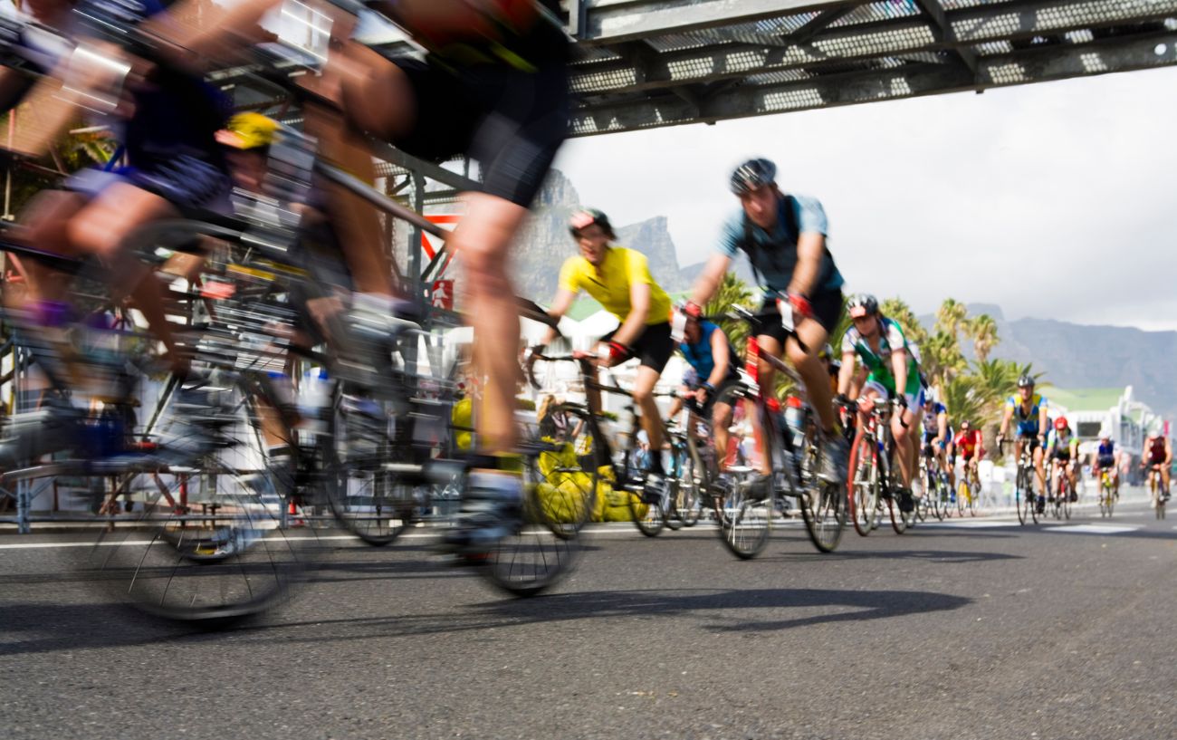 A pack of riders pass under the line during a criterium.