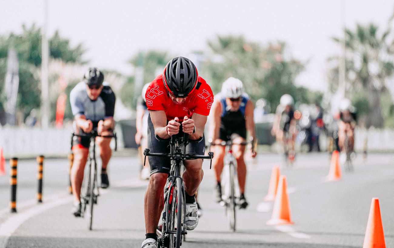 A duathlete in a red jersey approaches a transition zone.