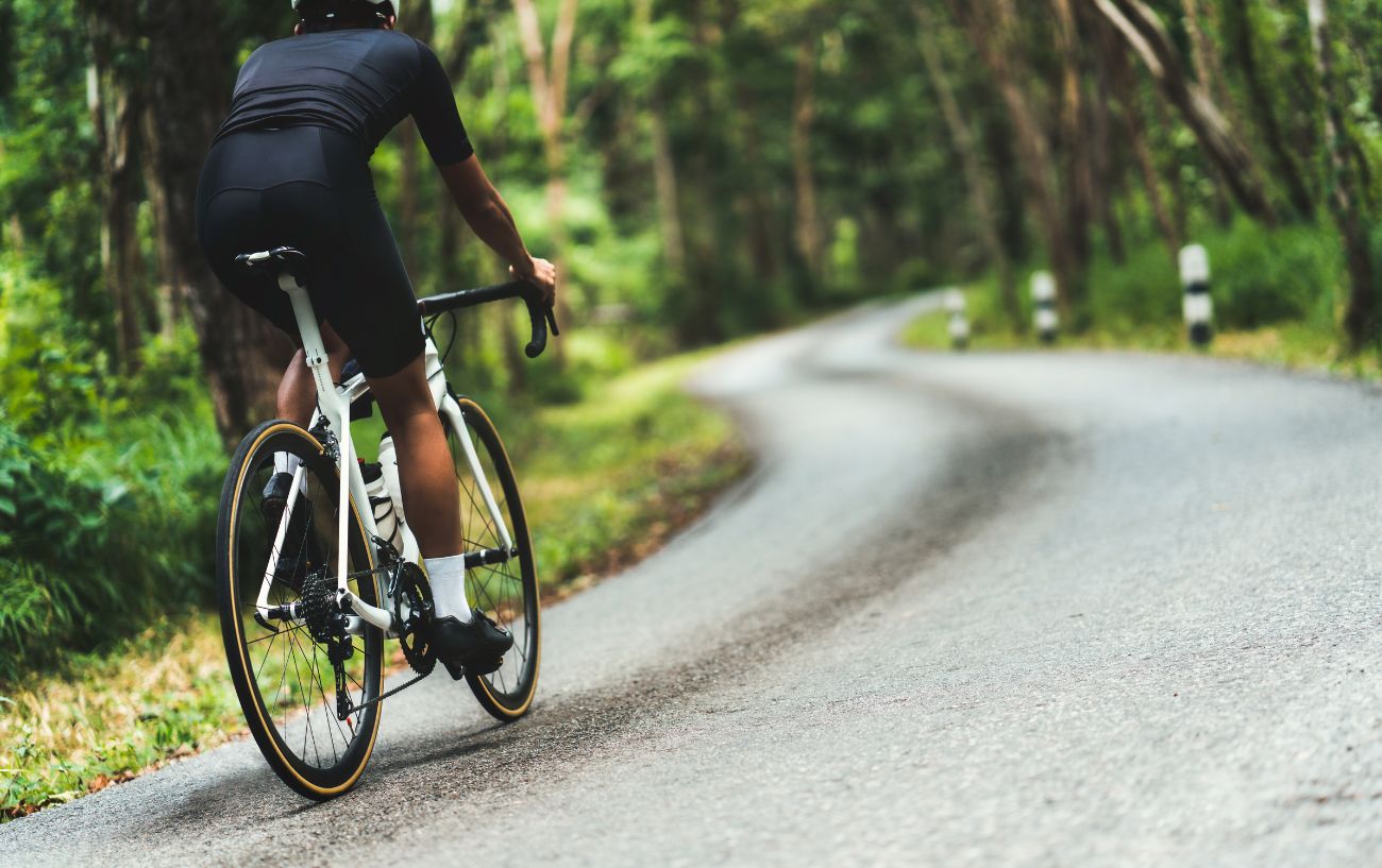 A cyclist rides up a steep hill to put their VO2 max to the test.
