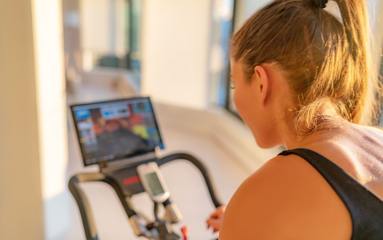 A cyclist removes and reinstalls the Peloton app on her bike.