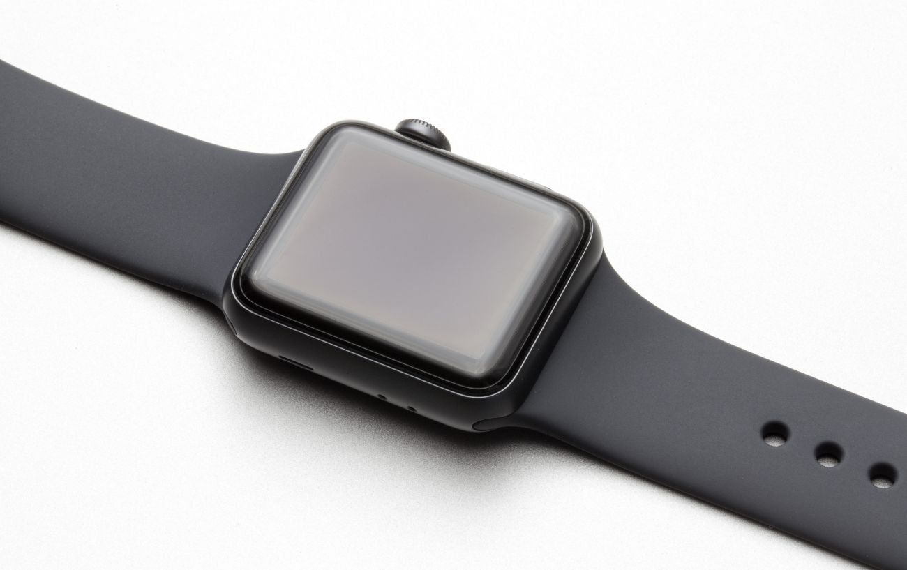 An Apple Watch lies on a white surface during a force restart.