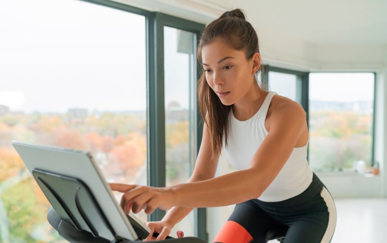 A woman restarts her Peloton bike.