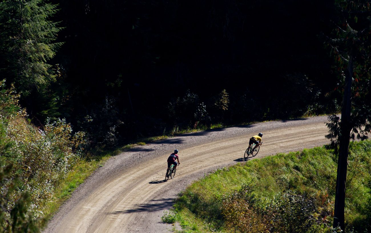 Two gravel bike racers round a corner.