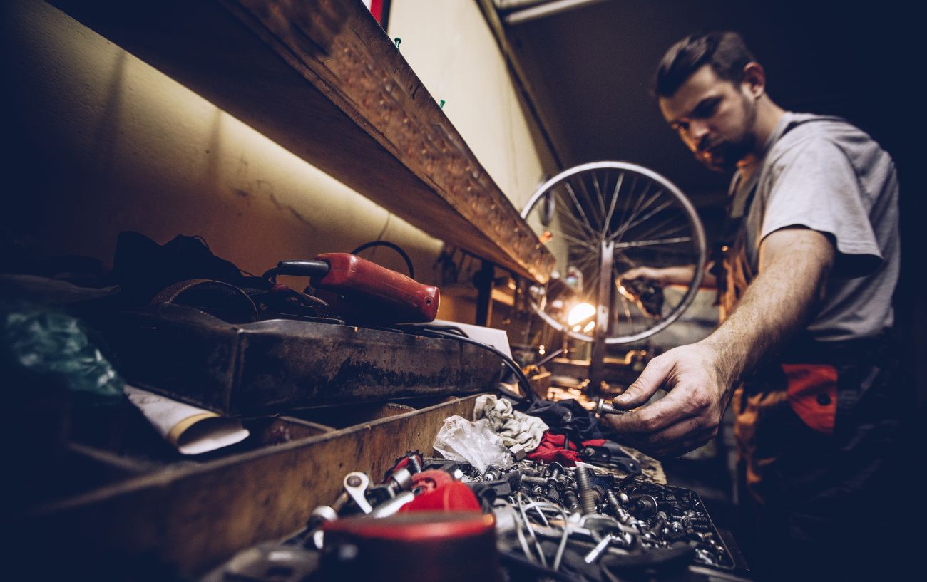 A bike mechanic reaches for his toolbox while building a bike.