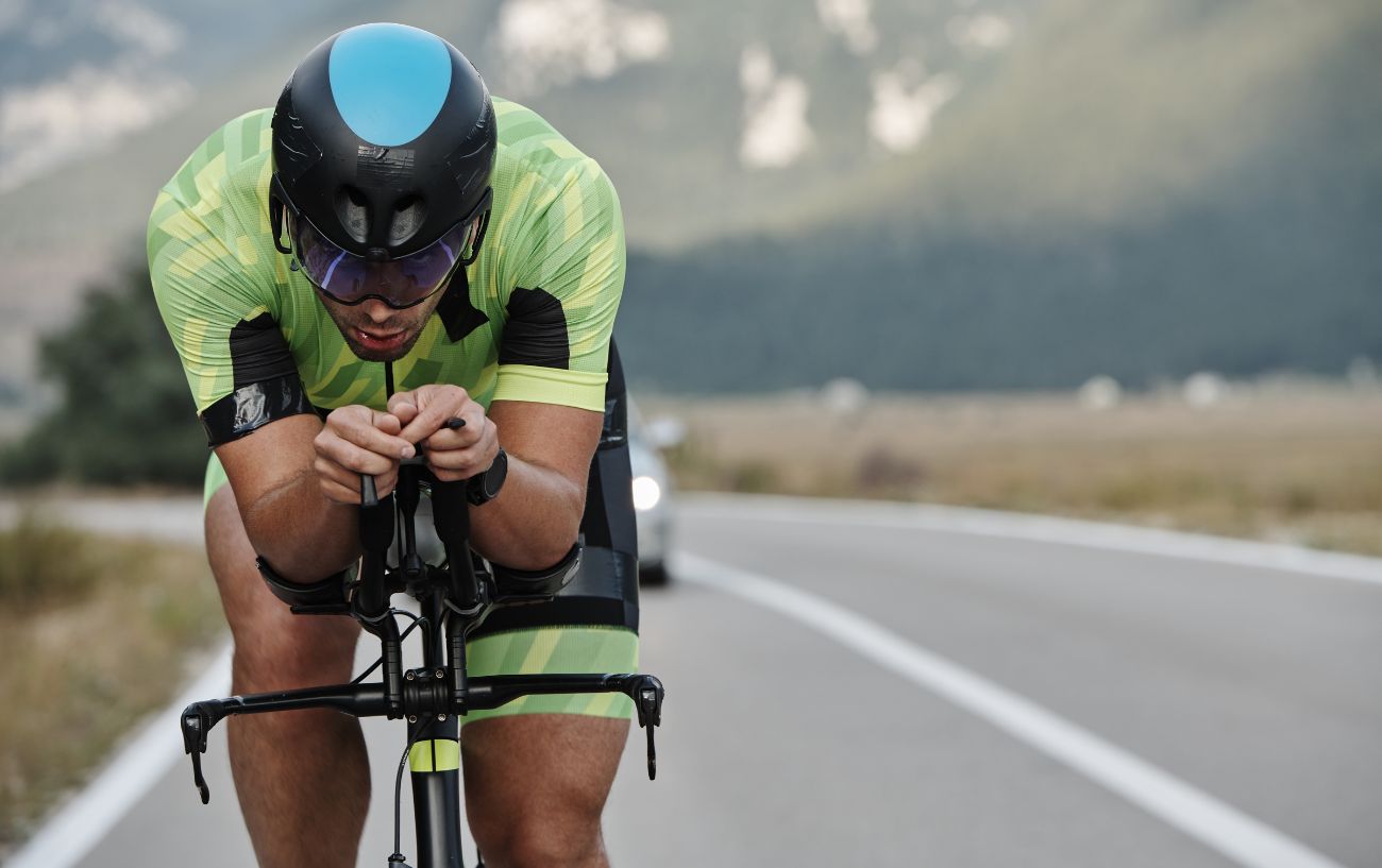 A triathlete using aero bars demonstrates the position that Puppy Paws replicates.