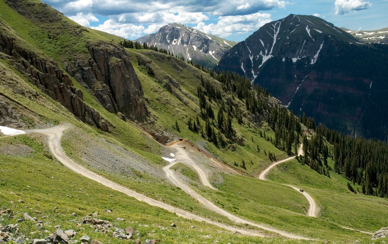 An Alpine mountain with a switchback trail snaking down the face.