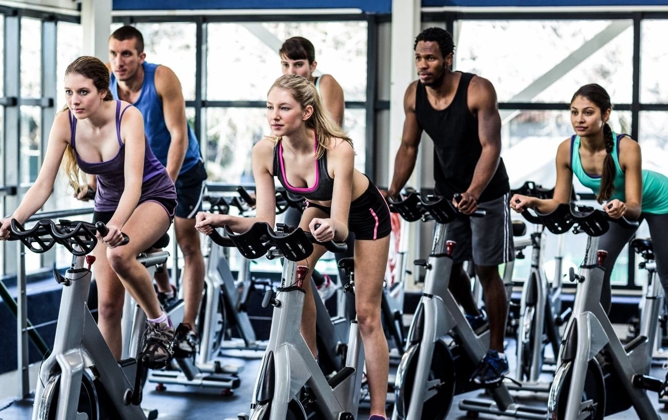 A group of cyclists take part in a spin class.