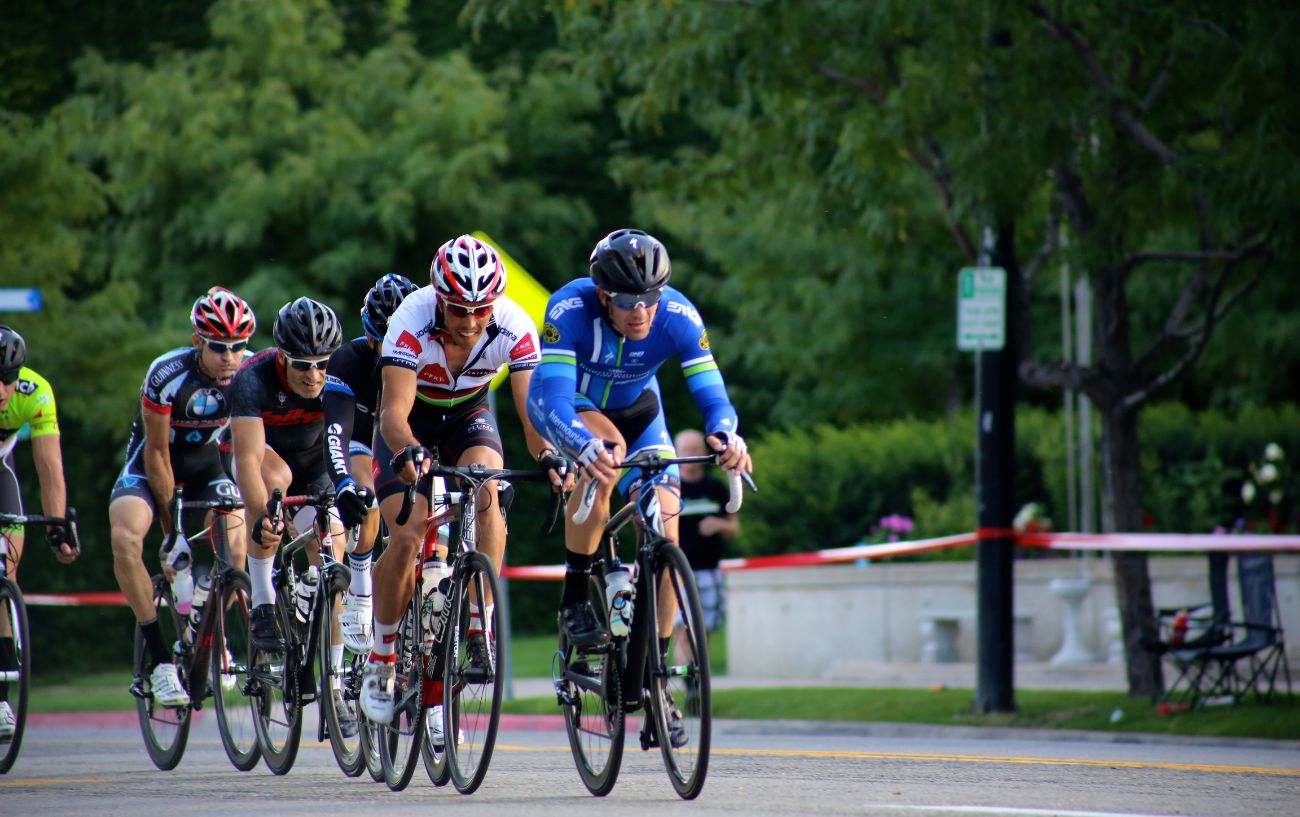 A group of cyclists with shaved legs ride on the road.