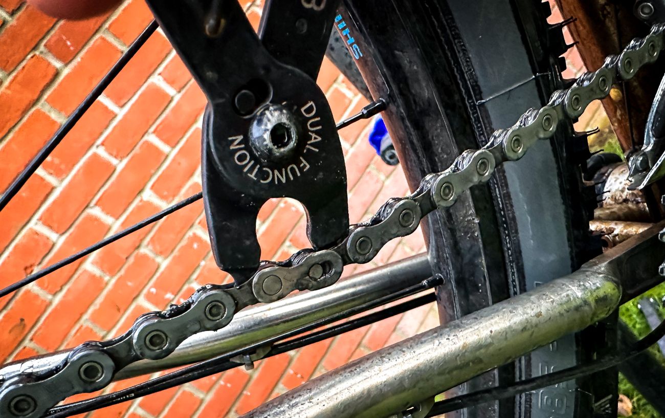 Reattaching a bike chain using master link pliers.