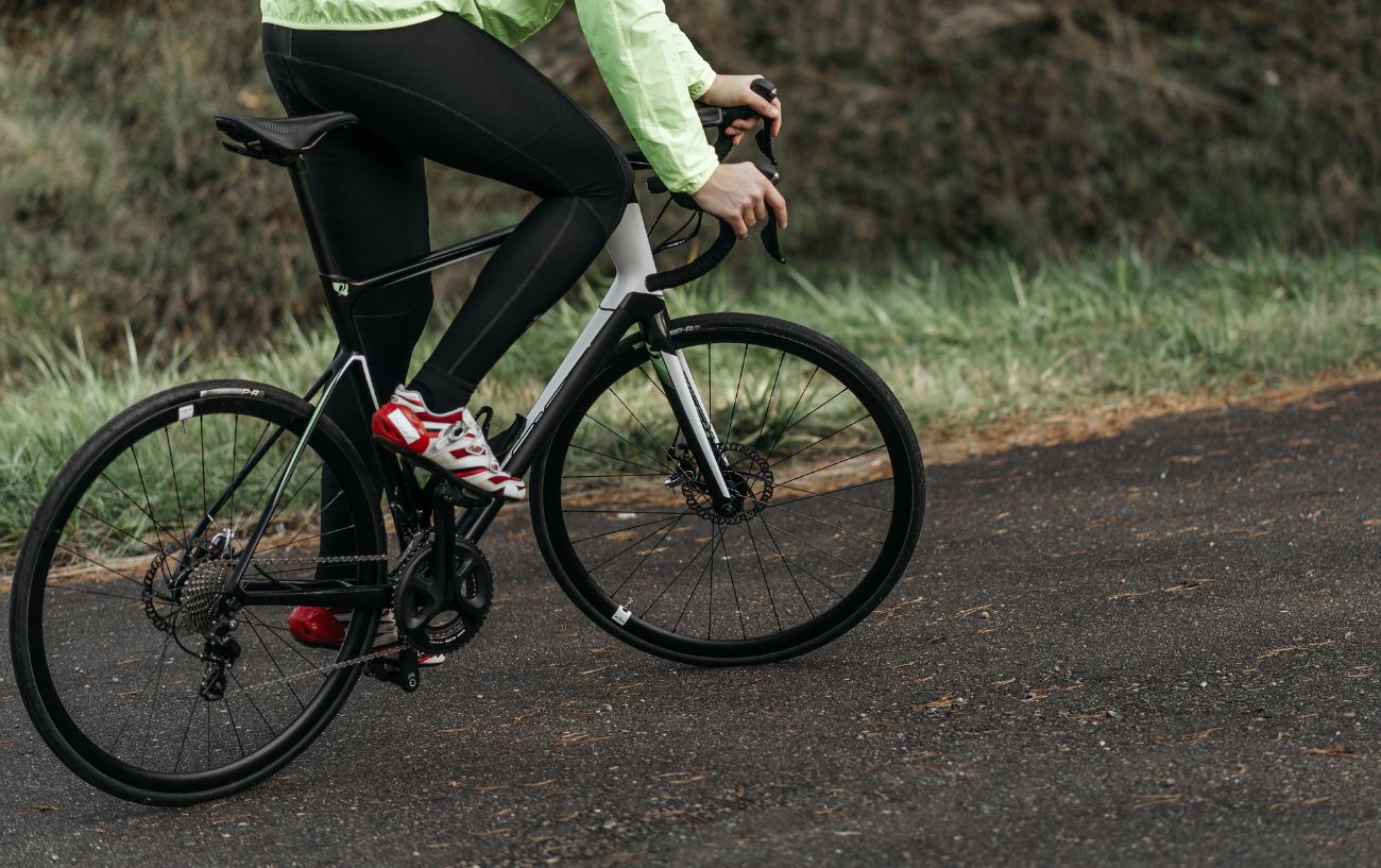 A cyclist rides an endurance road bike on a tarmac road in winter.