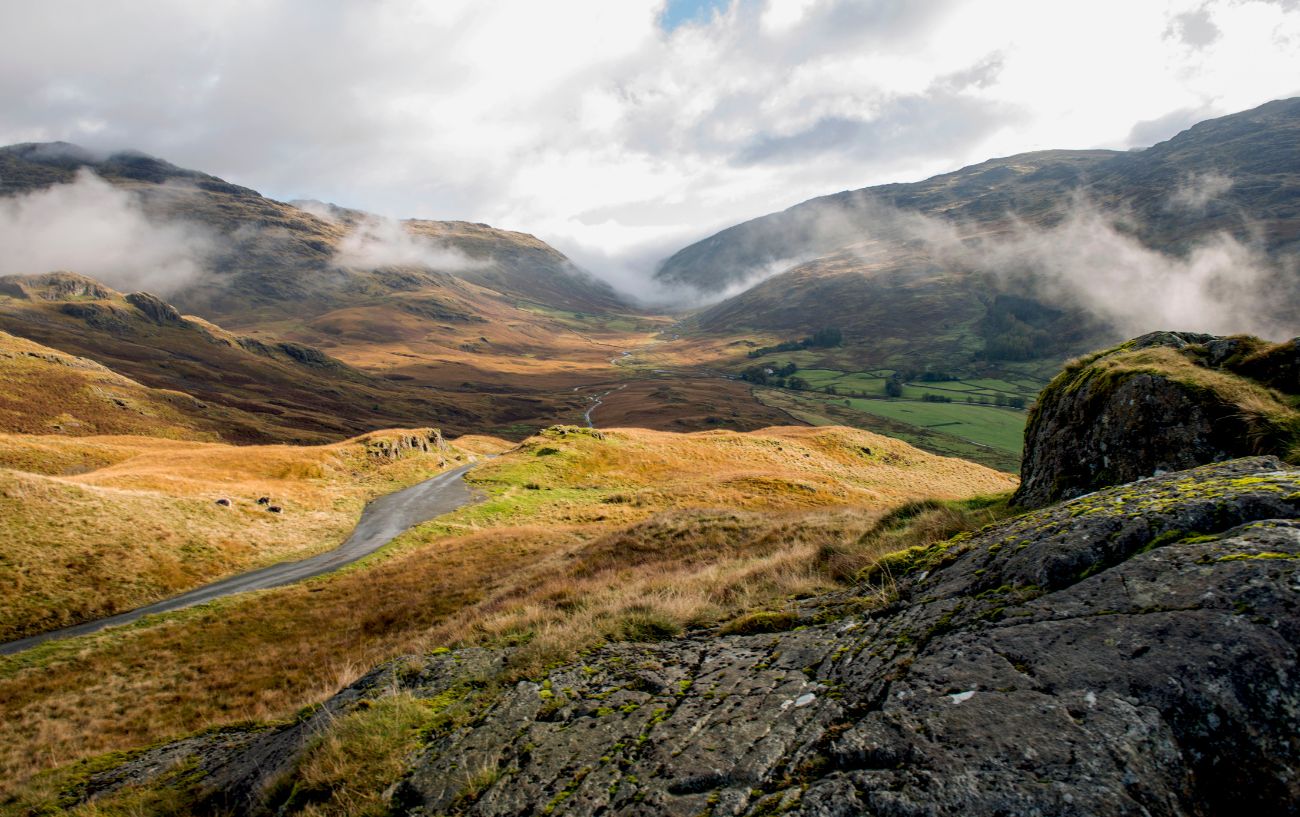 View over the misty valley containing Hardknott Pass.