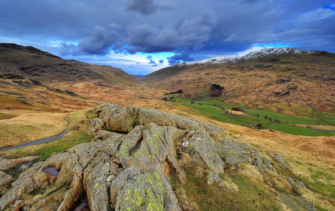 View of snow-capped peaks in the Lake District with Hardknott Pass snaking through.
