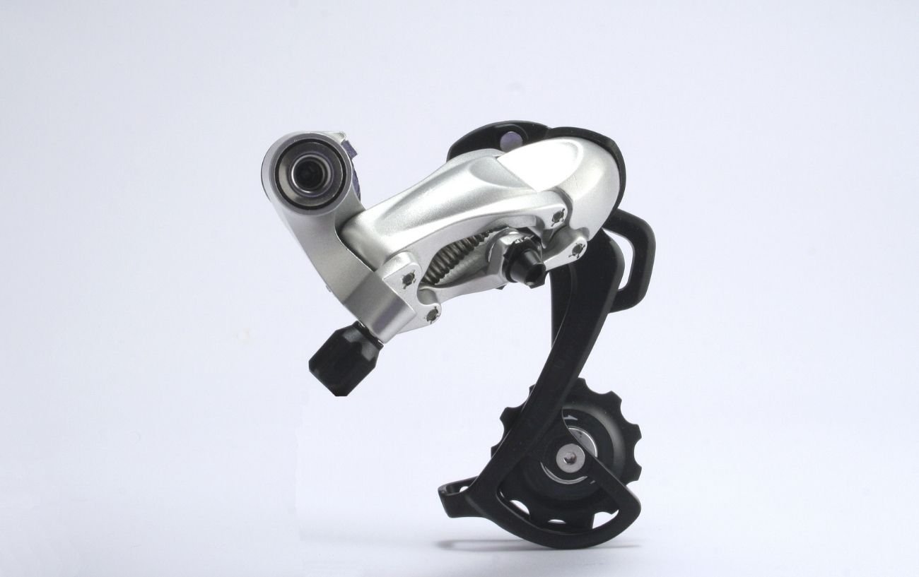 Photo of a silver derailleur against a grey background.